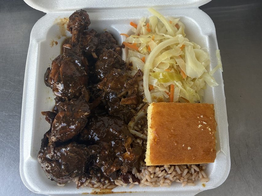 Brown stew chicken with rice and peas, steamed cabbage and cornbread