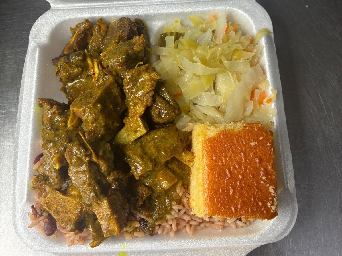 Curry goat with rice and peas, steamed cabbage and cornbread