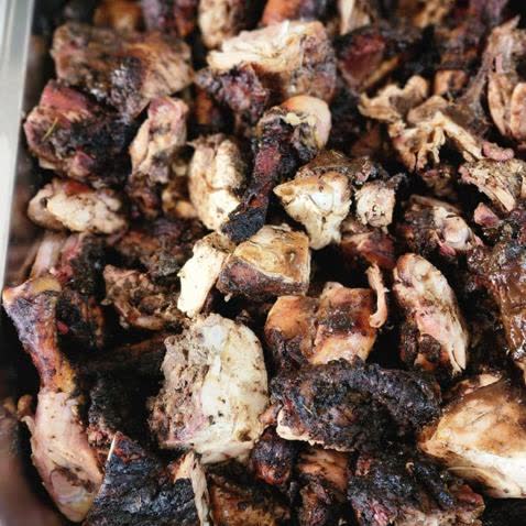 A full pan of jerk chicken, chopped and charred